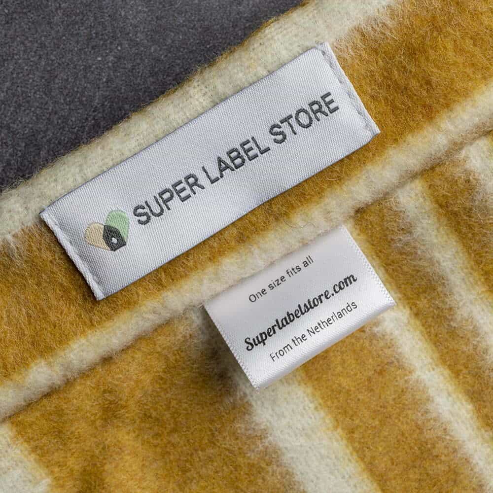 White Super Label Store brand label stitched onto mustard and cream striped fabric beside a small size and origin tag.
